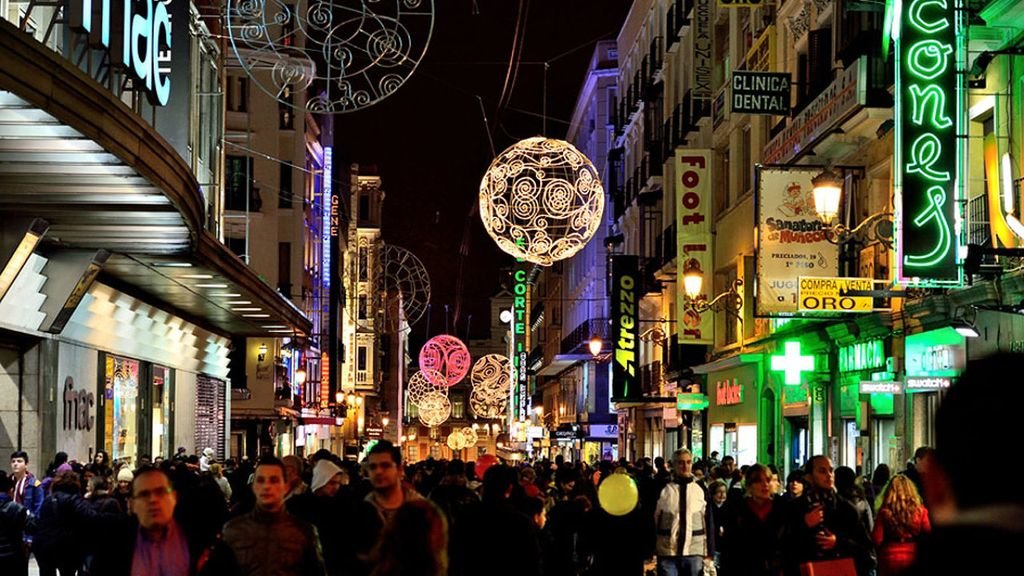 Numerosas personas caminan por la céntrica y comercial calle Preciados de Madrid en Navidad.