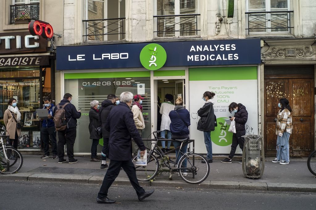 Un grupo de personas hace cola a las puertas de un laboratorio de análisis clínicos en París.