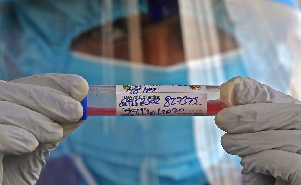 Un científico sostiene un tubo de ensayo relacionado con el desarrollo de una vacuna.