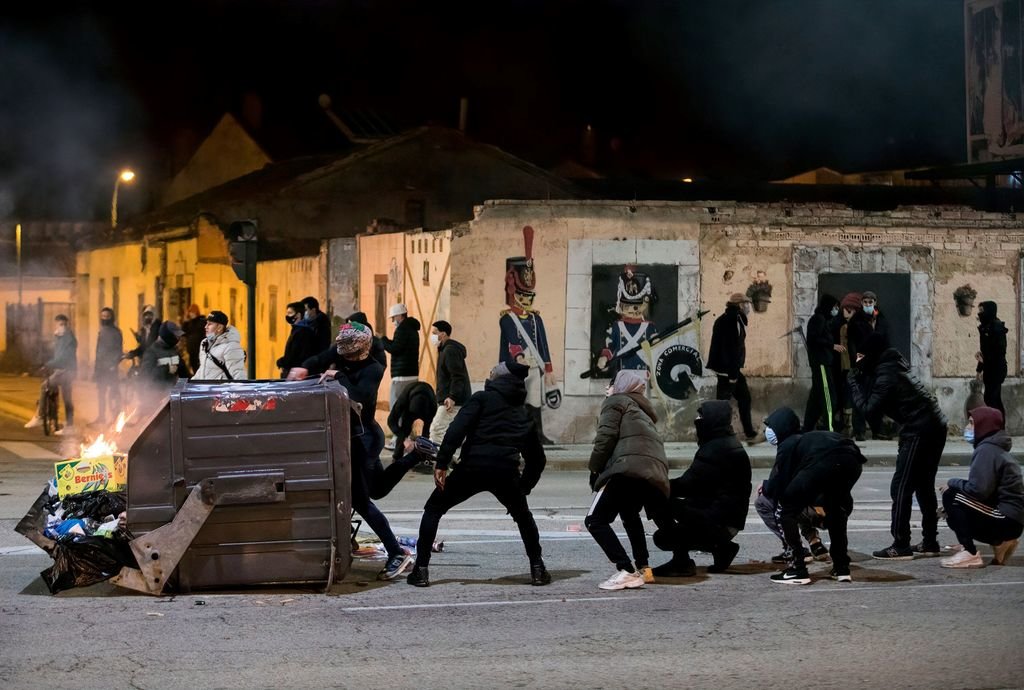 Un grupo de radicales se enfrenta a la policía parapetado en un contenedor, en Burgos.