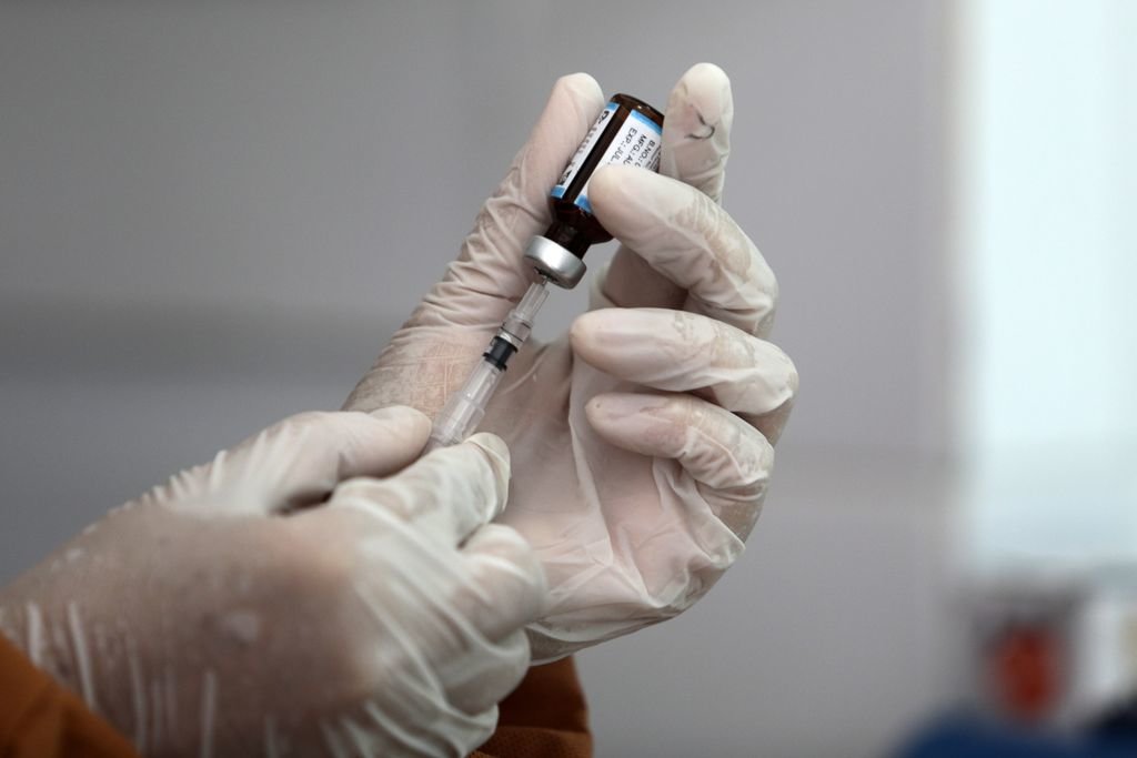 Un sanitario prepara una de las dosis de una vacuna para suministrarla.