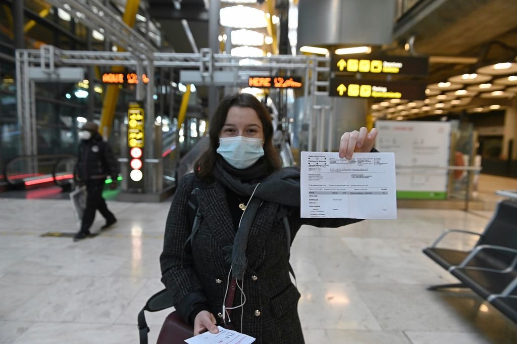 Una joven muestra su PCR negativa en las instalaciones del aeropuerto Adolfo Suárez de Madrid.