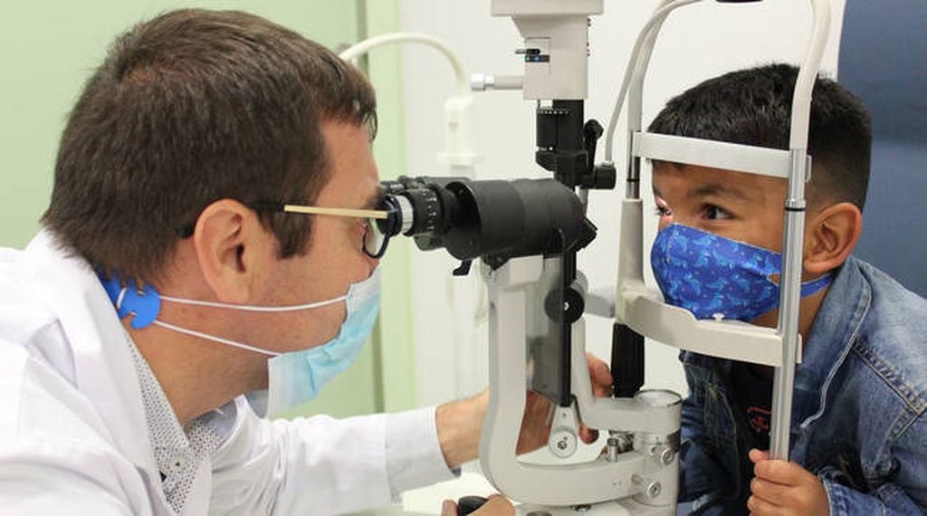 El doctor Jaume Català realiza un control a Félix, el niño que superó su cáncer de retina.