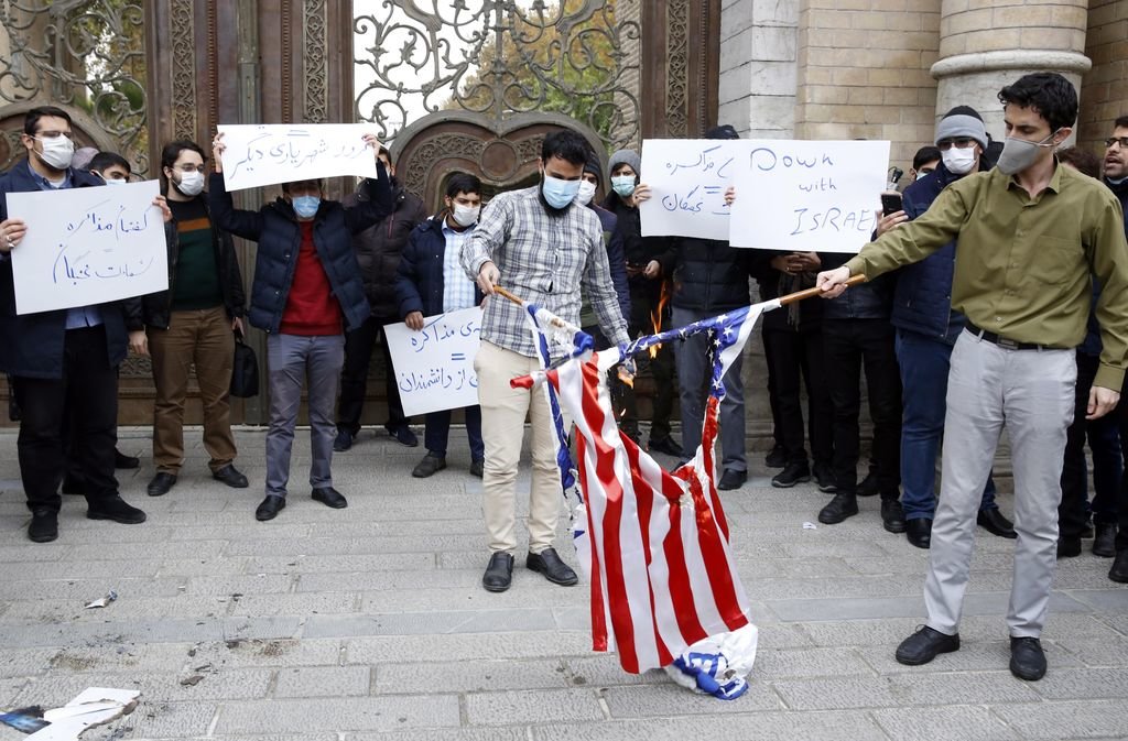Un grupo de jóvenes quema una bandera de Estados Unidos frente a la sede del Ministerio de Exteriores.