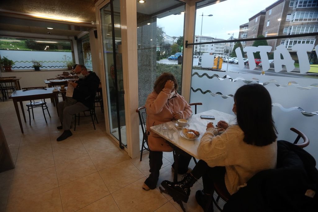 Un grupo de personas desayuna en una cafetería de Santiago tras la apertura ayer de la hostelería.