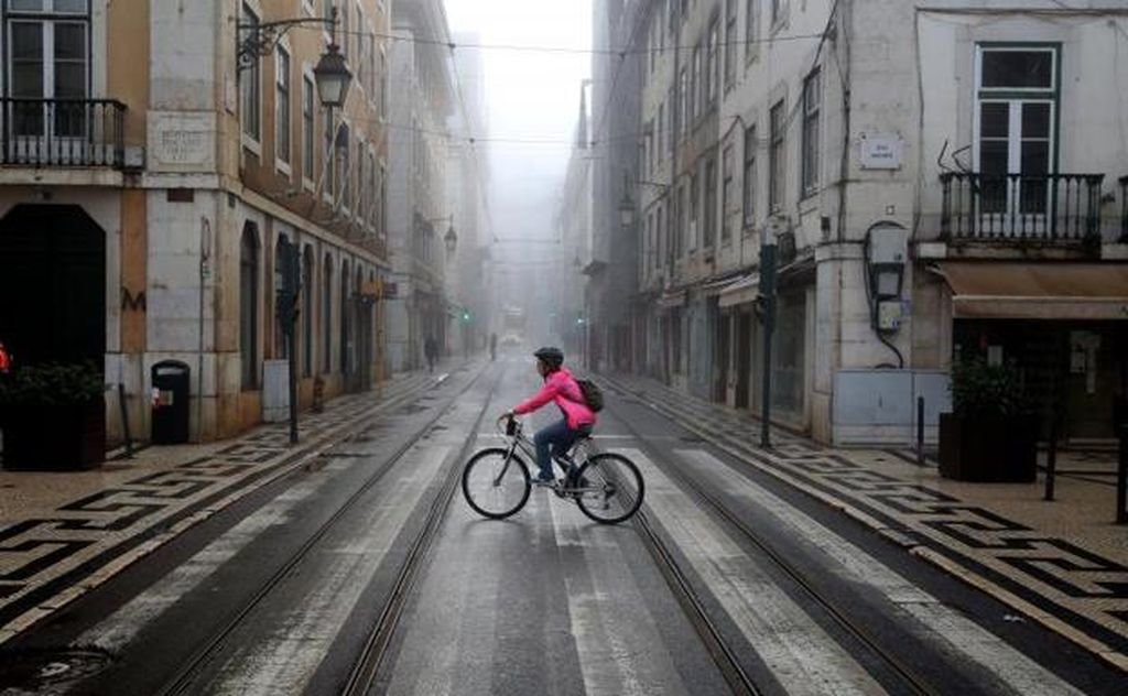 Una mujer en bicicleta circula por una calle del centro de Lisboa, en Portugal.