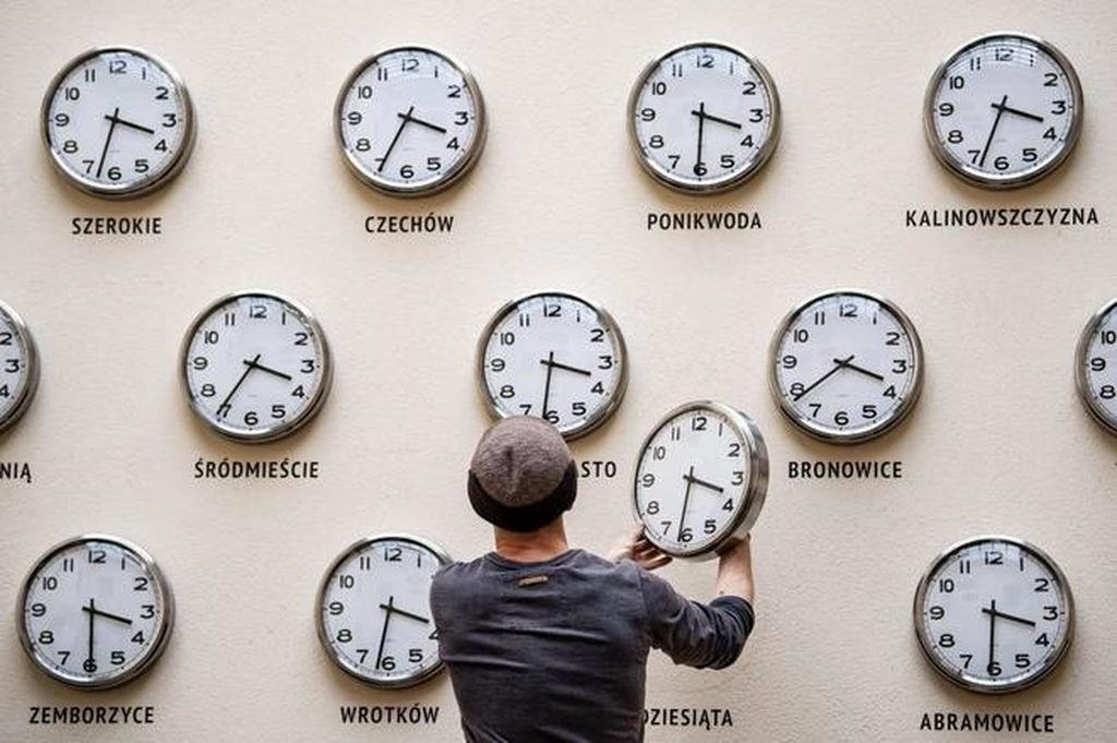 Un hombre cambia la hora de varios relojes según el país.