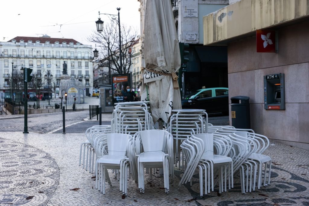 Varias mesas y sillas de una terraza del centro de Lisboa permanecen recogidas.