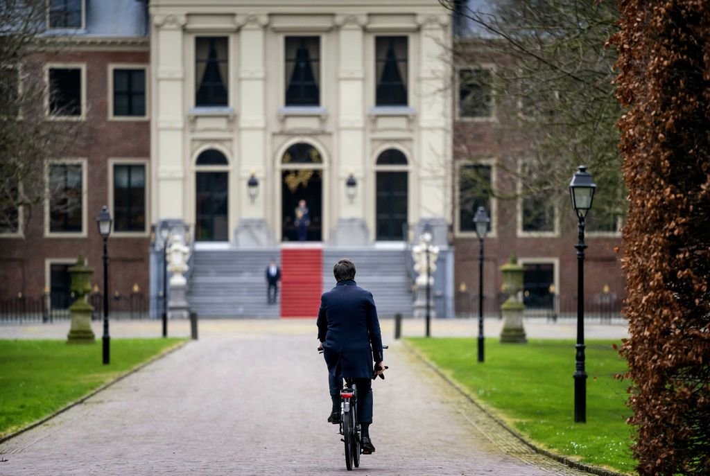 El primer ministro Mark Rutte llega en bibicleta al Palacio Huis ten Bosch para presentar su dimisión.