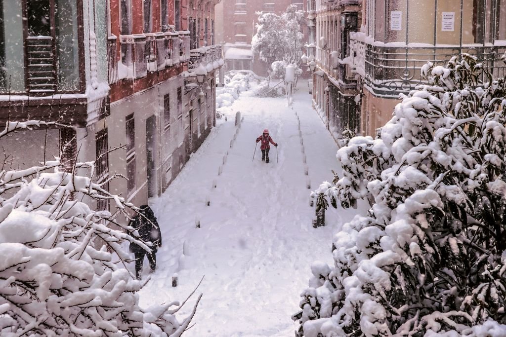 Una persona intenta avanzar sobre la nieve en una calle del centro de Madrid.