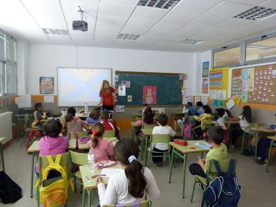 Varios estudiantes asisten a clase en las aulas de un colegio público.