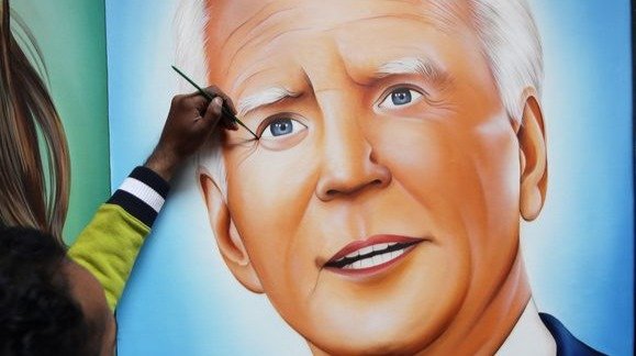 Un artista indio da los últimos retoques a un cuadro del presidente electo de EEUU, Joe Biden.