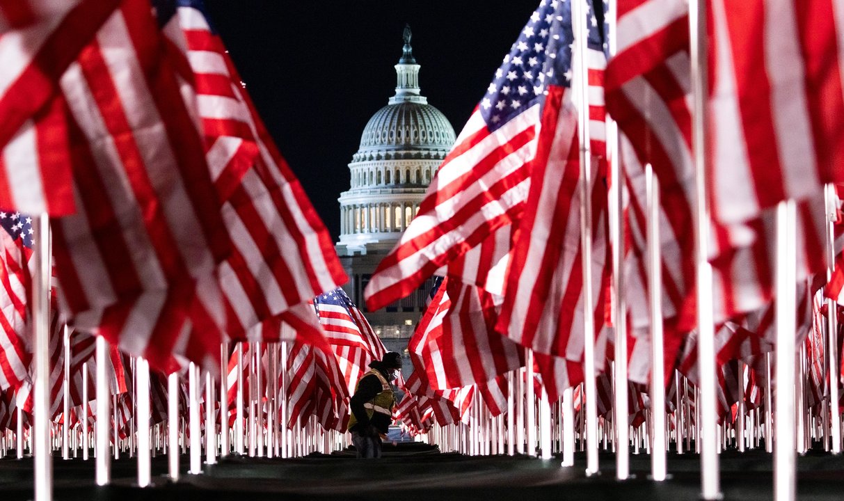 Una persona pasa entre las 200.000 banderas instaladas frente al Capitolio para la investidura de Biden