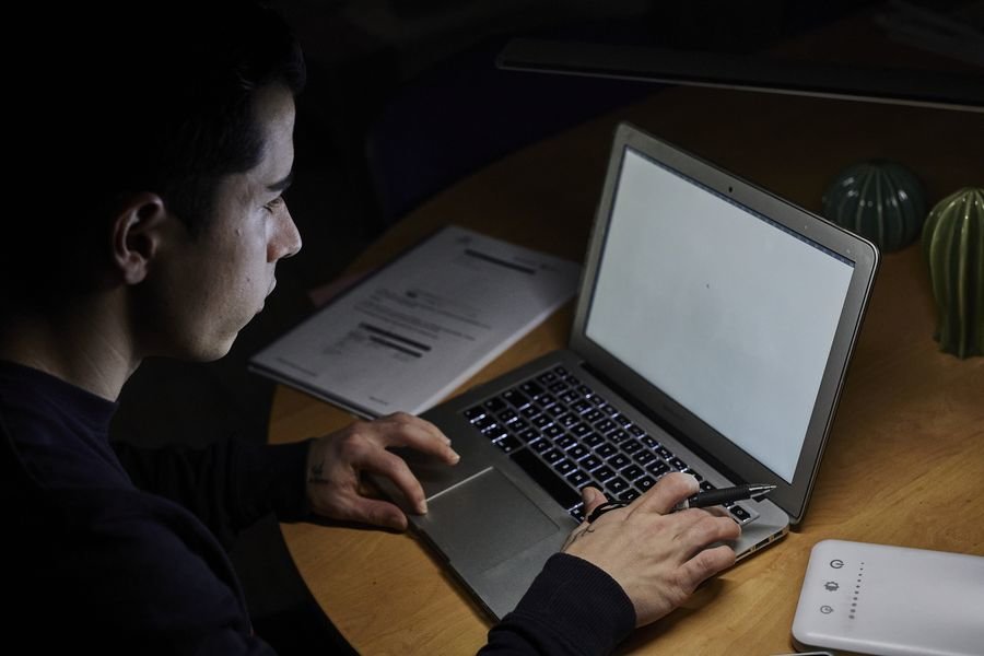 Una hombre trabaja con su ordenador portátil desde su casa.