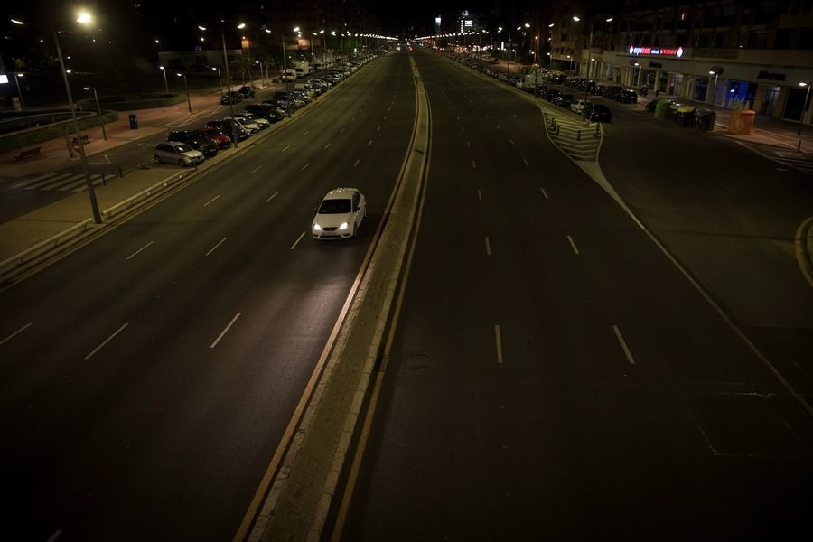 Un coche circula de noche en solitario por una avenida de Valencia durante el estado de alarma.