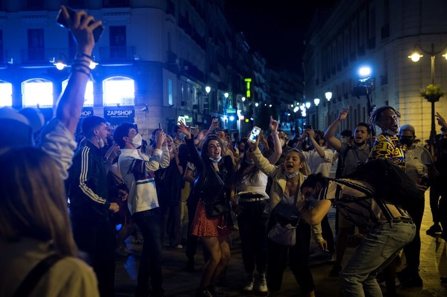 Jóvenes bailando y bebiendo para celebrar el fin del estado de alarma en la Puerta del Sol de Madrid.