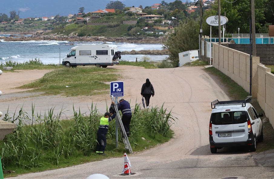 Operarios municipales destapando las señales en Patos el 14 de mayo, posteriormente tapadas por los agentes.
