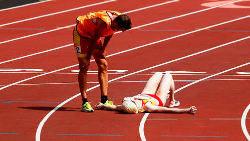 Susana Rodríguez, en el suelo exhausta, junto a su guía en atletismo, el vigués Celso Comesaña. 

EFE