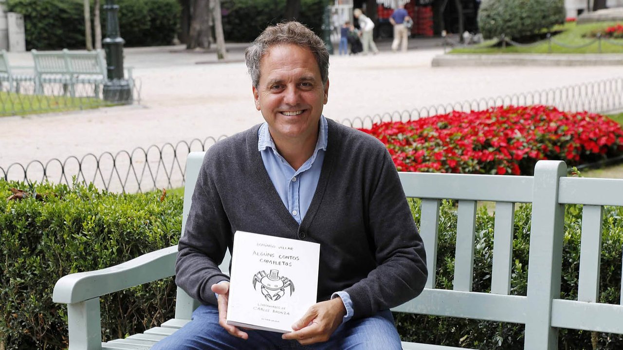 Domingo Villar posa con el libro en Praza de Compostela.
