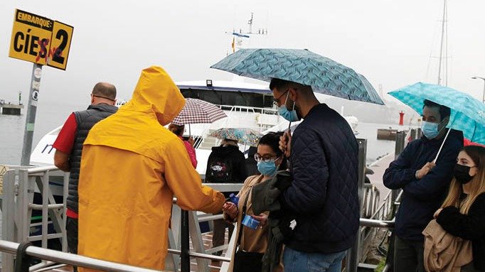 Emarque de viajeros a Cíes bajo el paraguas ayer por la mañana.