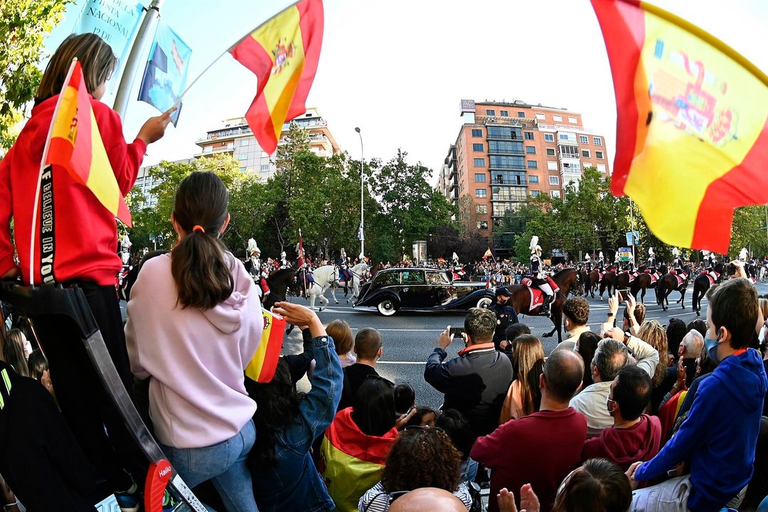 Llegada del coche de los Reyes Felipe y Letizia, al desfile militar del 12 de Octubre por el Paseo de la Castellana de Madrid para festejar este martes el Día de la Fiesta Nacional. // EFE/Fernando Villar