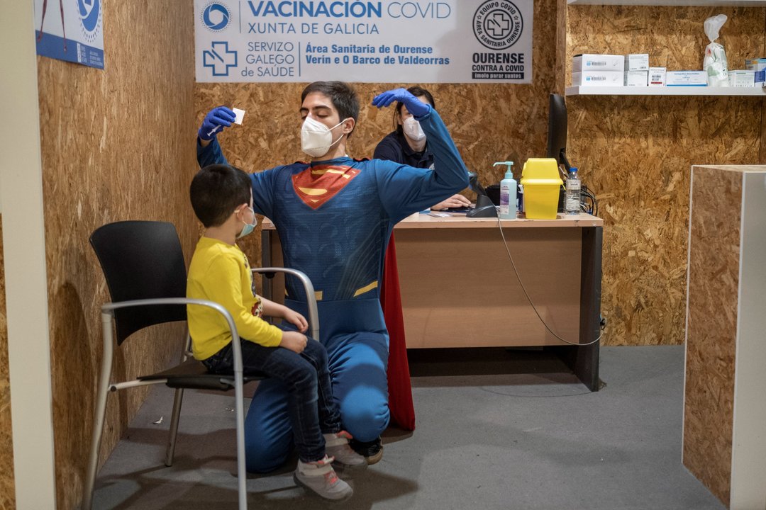 Un sanitario vestido de superhéroe antes de vacunar a un niño en Ourense.