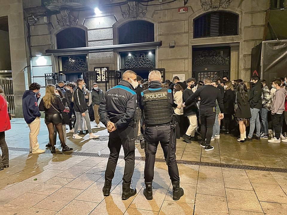 Dos policías locales vigilan a un grupo de jóvenes congregados en un local de ocio nocturno en Vigo.