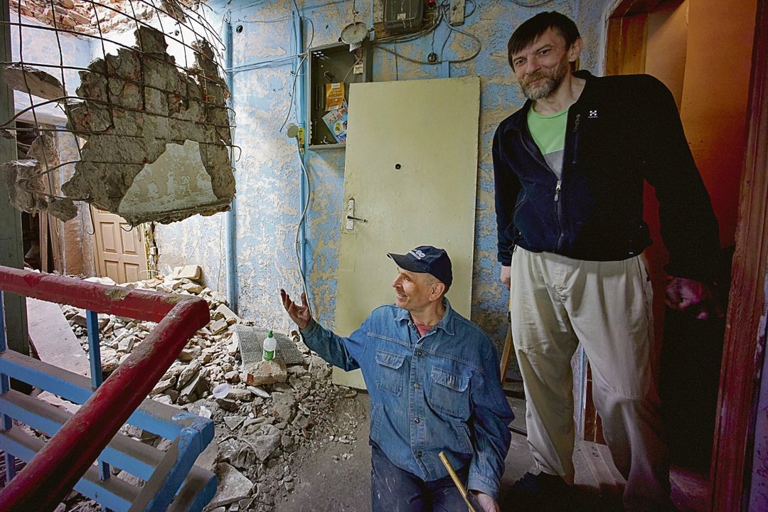 Dos hombres en un edificio residencial dañado en un bombardeo en Kharkiv, Ucrania.
