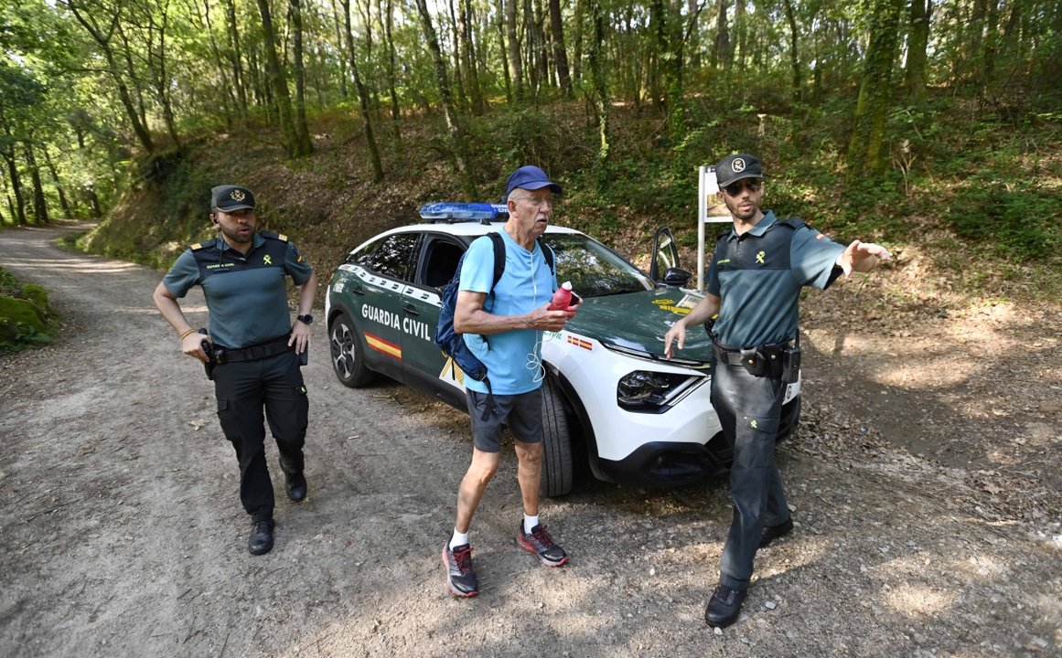 Dos agentes de la Guardia Civil de Tui ayudan y orientan a un peregrino del Camino Portugués.