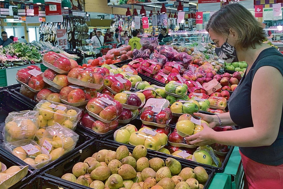Una mujer mira el precio de las manzanas en un supermercado de Madrid.