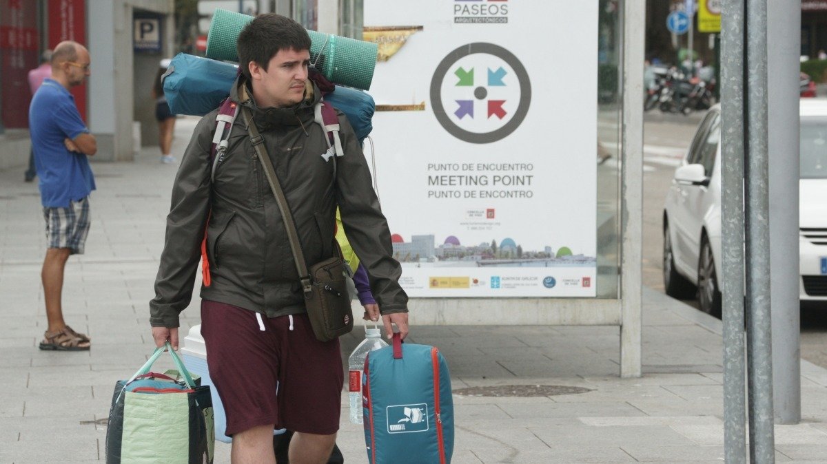 Una imagen cada vez más habitual y que se repetirá este verano: un turista por el centro de Vigo con sus maletas.