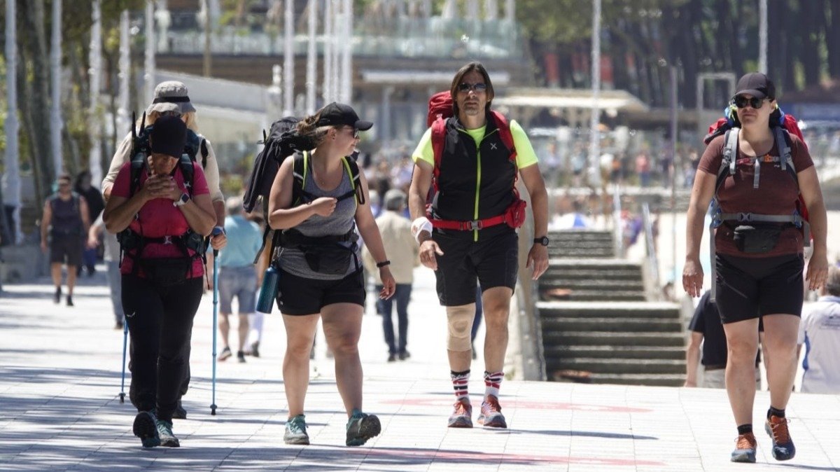 Un grupo cruzando Samil, extranjeros haciendo el Camino de la Costa a Santiago
