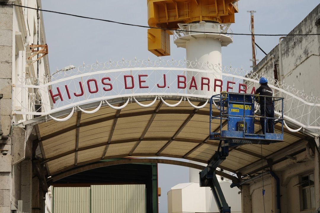 Un operario retirando el rótulo de Hijos de J. Barreras de la entrada del astillero hace dos semanas.