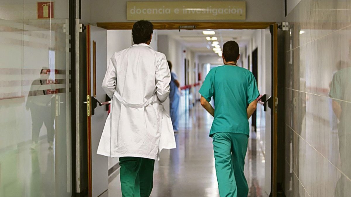 Dos médicos, en el pasillo de un hospital.