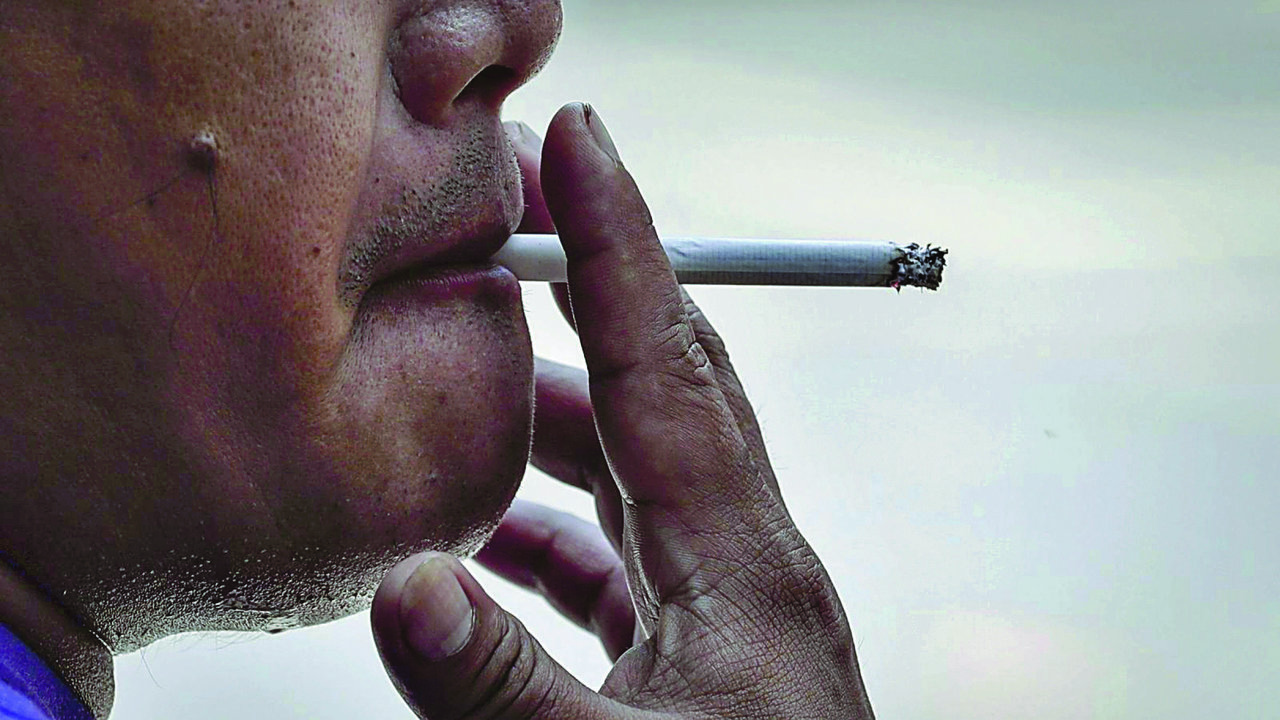 Un hombre fumando un cigarrillo.