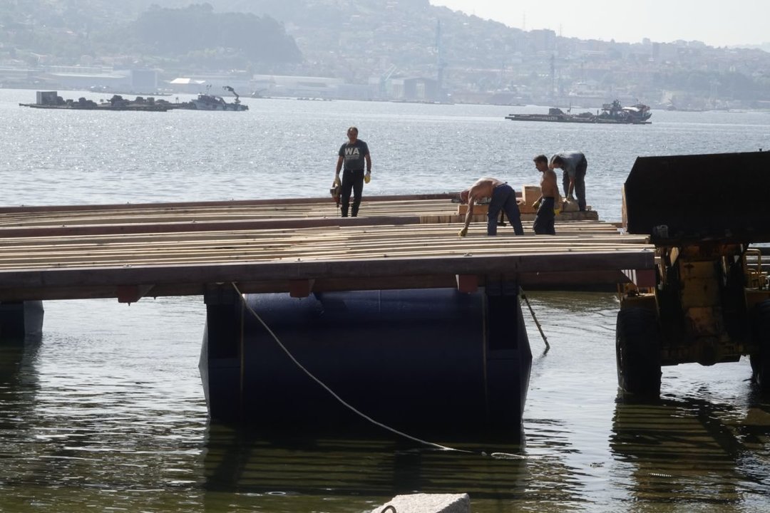 Trabajando en la reparación y montaje de una de las bateas de la Ría de Vigo. A la derecha, la reunión de cofradías de pesca de las Rías Baixas.