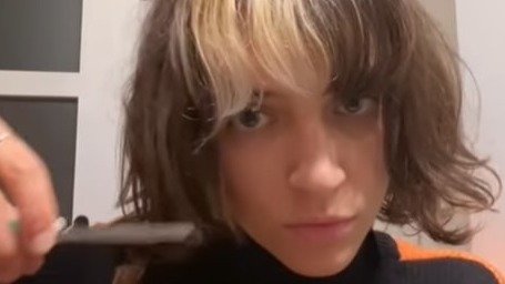 Una artista francesa cortándose un mechón de pelo en el vídeo viral