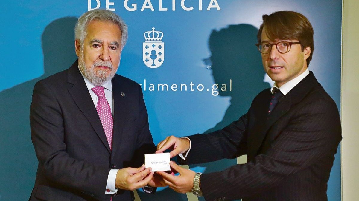 El conselleiro de Facenda, Miguel Corgos, entrega las cuentas al presidente del Parlamento, Miguel Santalices.