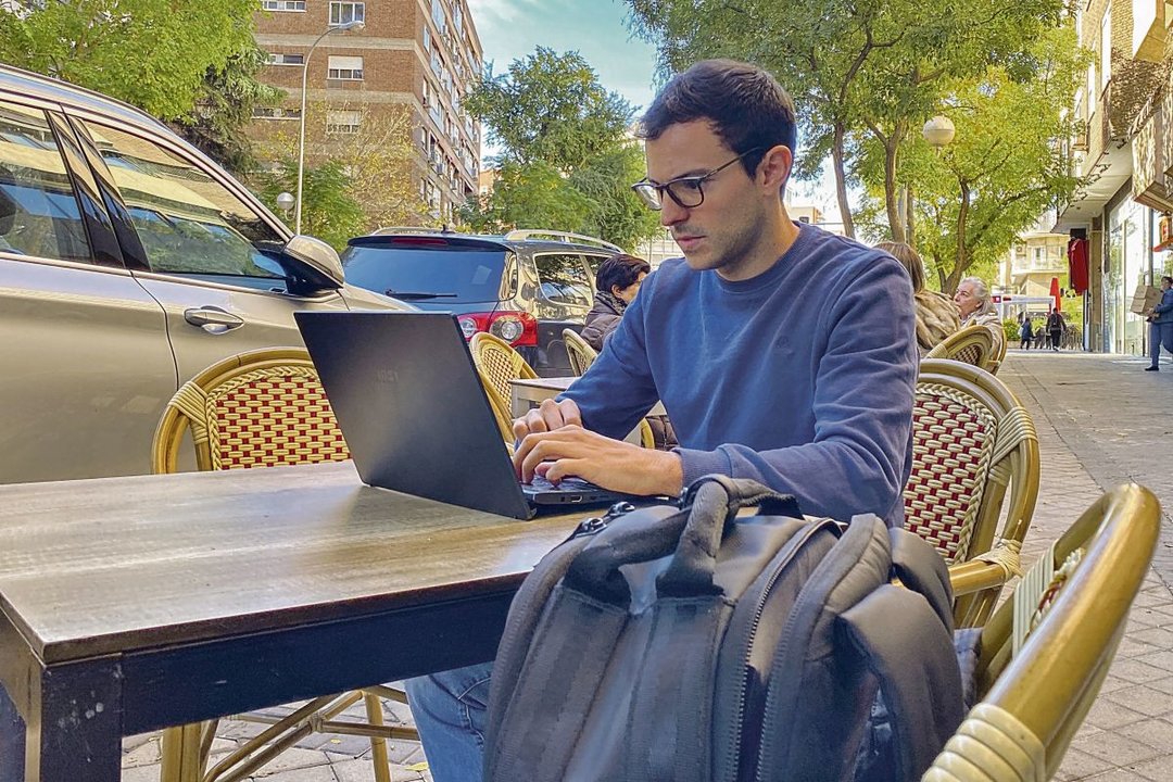 Alfonso Mena contesta correos electrónicos en la terraza de una cafetería.