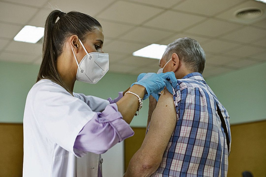 Una enfermera inocula la vacuna de la gripe a un hombre.