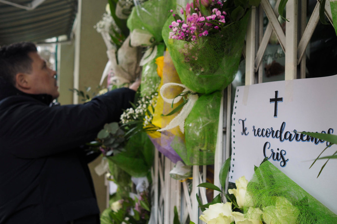 Vecinos de Lugo dejan ramos y flores en el local de la mujer asesinada. // EFE