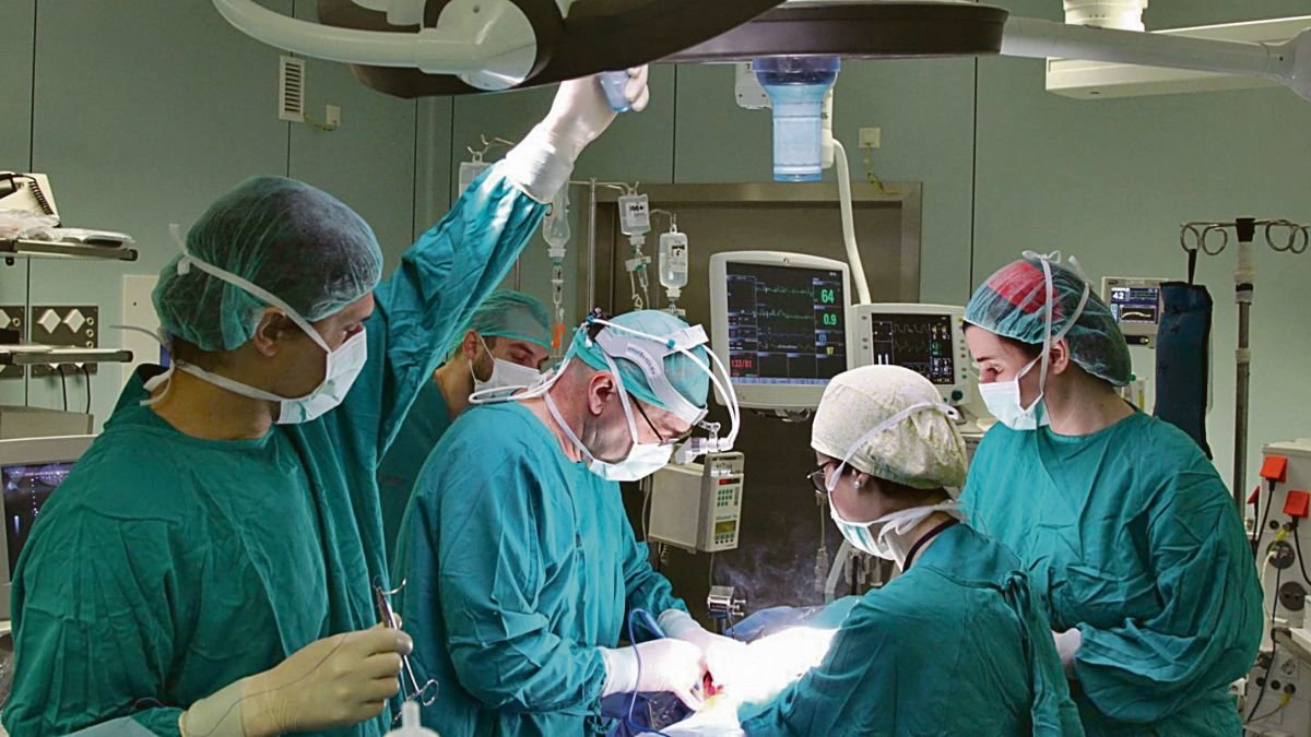 Varios cirujanos en medio de una operación.