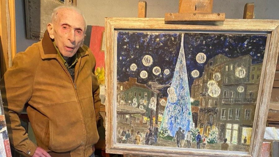 El pintor vigués Luis Torras, ayer en su estudio, al cumplir 110 años ante un cuadro de las luces de Navidad.