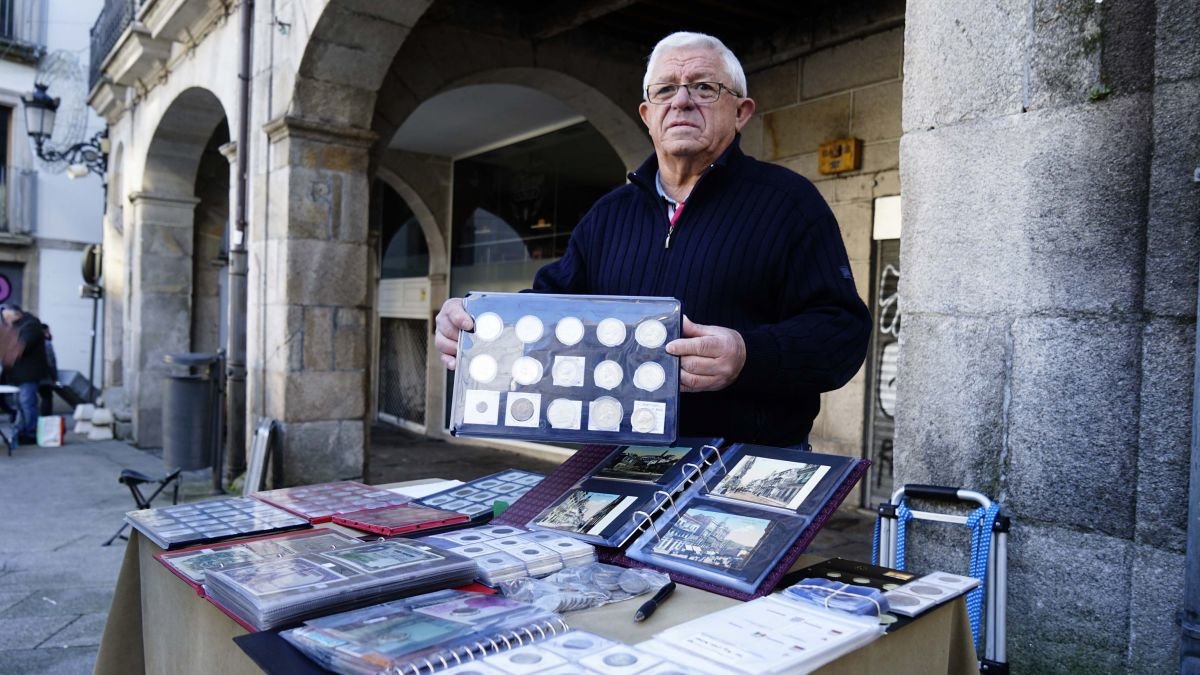 Manuel Mosquera muestra su colección de monedas en su puesto de la Plaza de la Constitución.