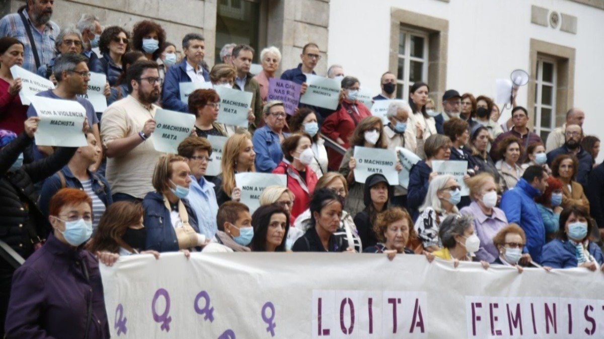 Las hijas del matrimonio sujetando la pancarta durante una concentración de repulsa por el crimen en Vigo.