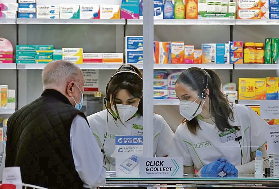Un cliente es atendido en una farmacia en Valencia.