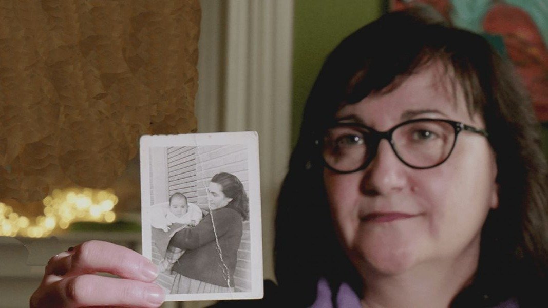 Soledad Luque, con una fotografía de su madre con ella de bebé, al poco de que la desaparición de su mellizo.
