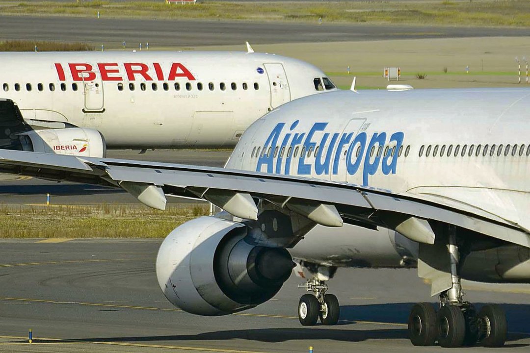 Un avión de Iberia y otro de Air Europa se cruzan en una pista de aterrizaje.