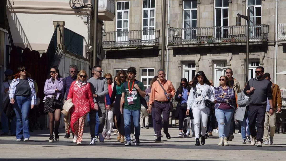 Un grupo de turistas pasean bajo las indicaciones de un guía por el centro de Vigo.