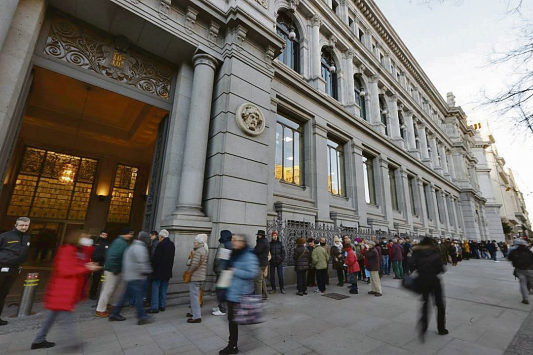 Colas de pequeños ahorradores ante el Banco de España para comprar deuda pública española.